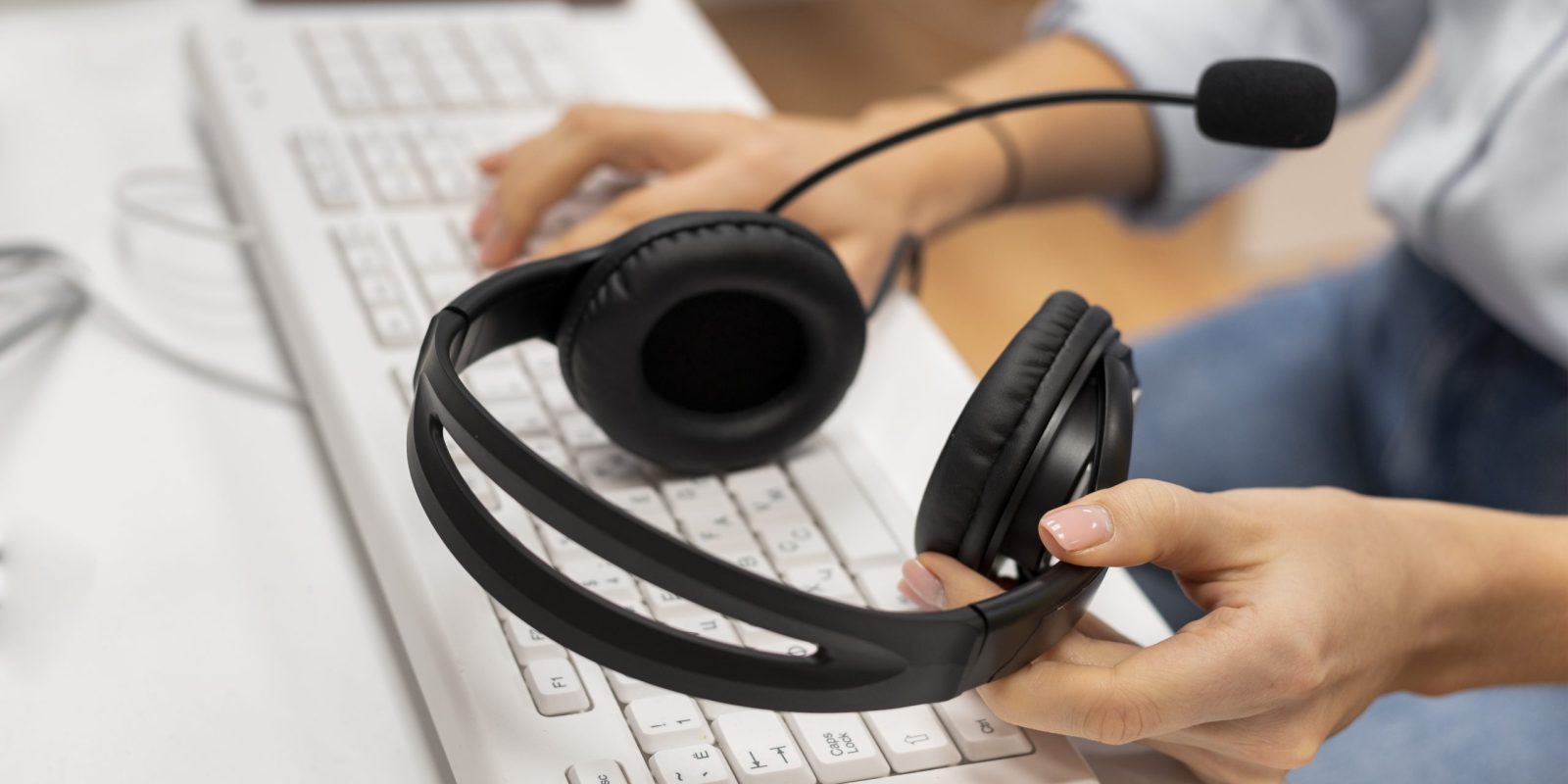 woman-working-call-center-holding-pair-headphones